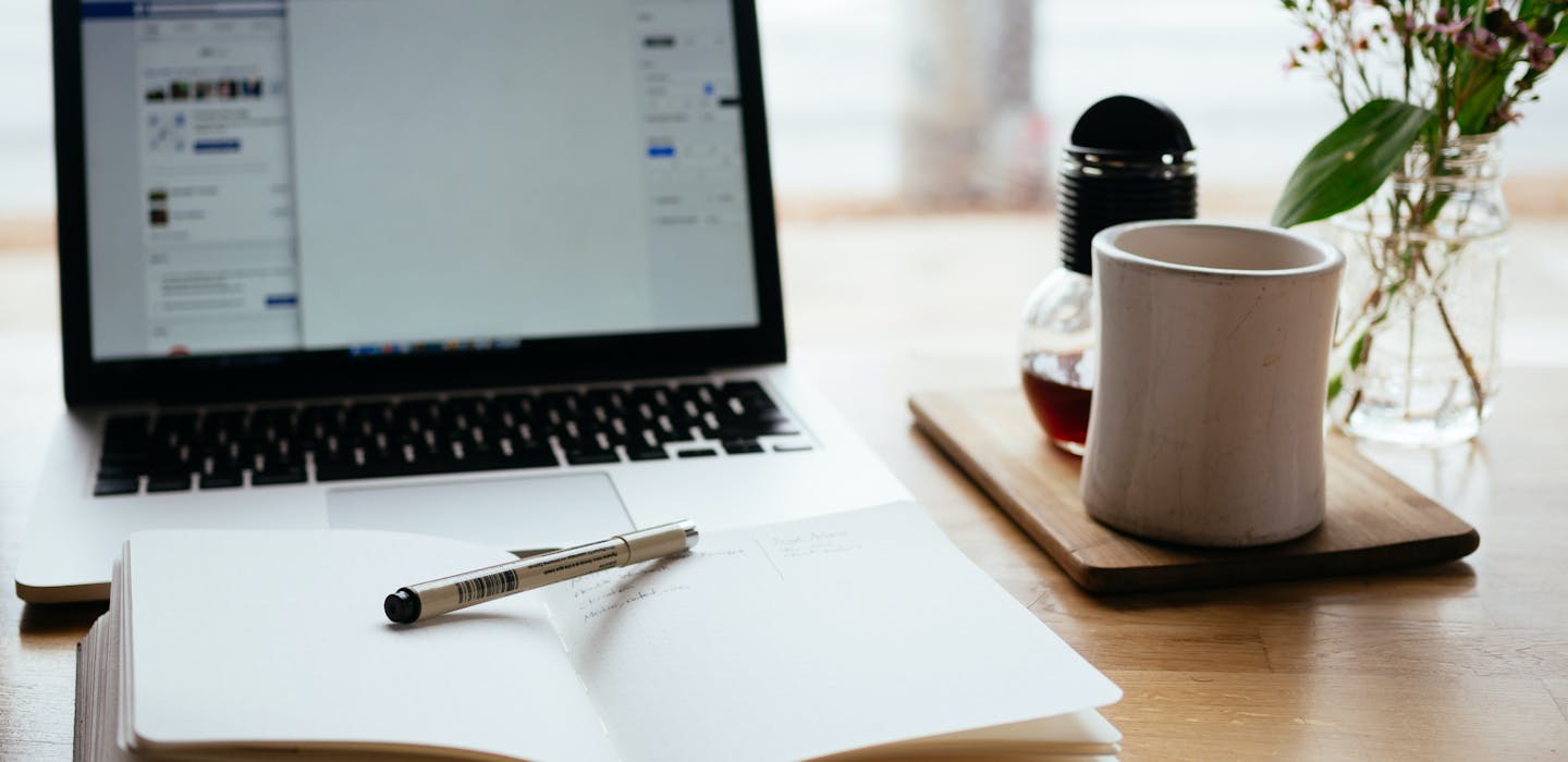 Handwerk-Troisdorf: Unser Blog - Ein Schreibtisch mit Laptop, Notizen und einer Tasse Tee